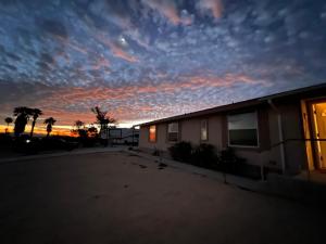 二十九棕榈村Bodhi House, Joshua Tree National Park的一座背面有日落的建筑