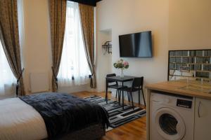 格拉斯哥S.H Apartments的酒店客房配有一张床和一台洗衣机