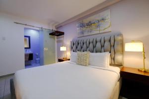 奥拉涅斯塔德Victoria City Hotel的一间带白色大床的卧室和一间浴室