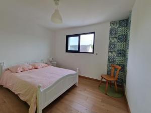 贝诺代Comfortable holiday villa in a quiet location in Bénodet的卧室配有床、椅子和窗户。