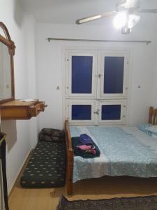 Dawwār Abū al ‘Āşīمارسيليا بيتش ١ شاليه的一间卧室配有一张床和一把椅子,还有两个窗户