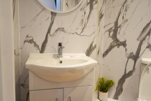 格拉斯哥S.H Apartments的浴室设有白色水槽和镜子