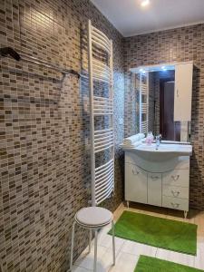 赫维兹Holiday home in Heviz - Balaton 44882的一间带水槽、凳子和绿色地毯的浴室