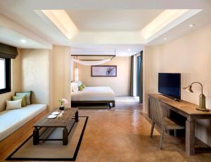 Ko NakaThe Naka Island, a Luxury Collection Resort & Spa, Phuket的一间客厅,客厅内配有一张床和一张书桌
