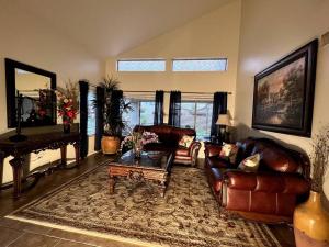 凤凰城La Posada de Lucy, LLC的客厅配有皮革家具和钢琴