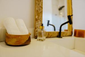 路易斯科雷亚Vila Caiada Guest House的浴室水槽设有肥皂机和镜子