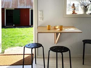法尔雪平Holiday home FALKÖPING II的桌子和两张凳子,上面有橙子杯