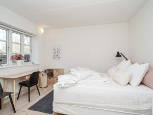 齐斯维勒莱厄Holiday home Tisvildeleje XVII的白色卧室配有书桌和带白色枕头的床