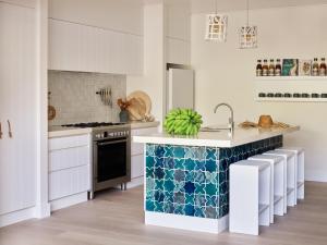 拜伦湾大西洋拜伦湾酒店的厨房配有白色橱柜和蓝色及白色瓷砖