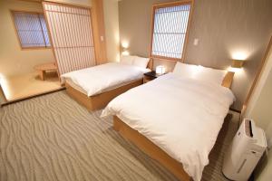 ShimmachidōriK-style Higashihonganji的酒店客房带两张床和两个窗户