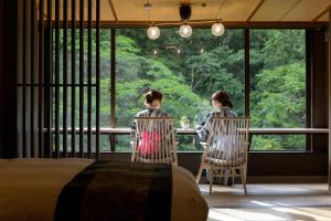 加贺山手香木酒店的两个人坐在一张桌子上,从窗户望出去
