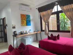 哈德姚Amara Beach Resort Koh Phangan的一间卧室设有两张床、一张桌子和一个窗口。