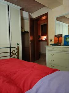 摩德纳Il Gioiellino di Modena - Elegant Apartment[☆☆☆☆☆]的一间带红色床的卧室和一间厨房
