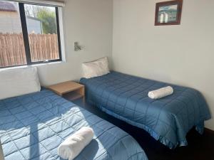 费尔利松林汽车旅馆的配有两张床铺的蓝色床单和窗户