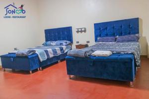 QuillabambaSONCCO LODGE-RESTAURANT的配有蓝色家具的客房内的两张床