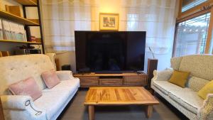 NamugilEver Healing House的客厅配有2张沙发和1台平面电视