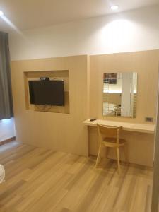 曼谷樱花天空公寓式酒店的一间房间,墙上有桌子和电视