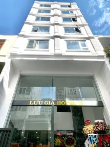 芽庄Luu Gia Hotel的一座高大的白色建筑,上面有标志