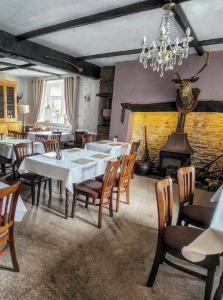WithypoolThe Royal Oak Inn的一间带桌椅和壁炉的用餐室