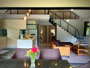 波拉波拉Fare Luna - Comfy New home in Bora Bora的厨房以及带花瓶的桌子的起居室