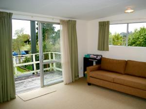 PoharaKea View - Pohara Beach Holiday Home的带沙发和滑动玻璃门的客厅