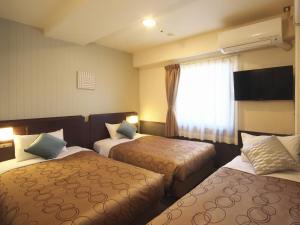 横滨横滨平和广场酒店的酒店客房设有两张床和窗户。