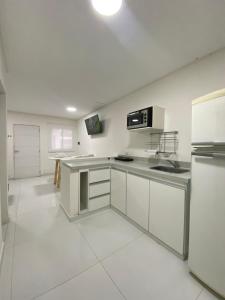 La RinconadaFama Suite YB的厨房配有白色家电,铺有白色瓷砖地板。