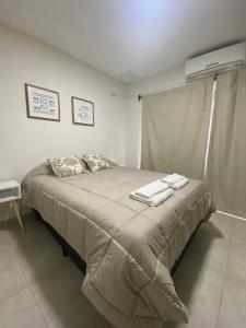 La RinconadaFama Suite YB的一间卧室配有一张床,上面有两条毛巾