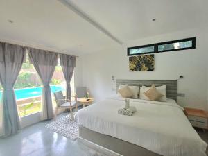珍南海滩Tisha Langkawi Wellness Resort的一间卧室设有一张床和一个大窗户