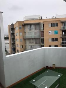 利马Hermoso Duplex en Chorrillos的阳台配有桌子和大楼