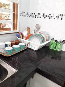 Pokok SenaCozy Homestay in Central Pokok Sena的厨房柜台设有水槽和碗碟干燥架