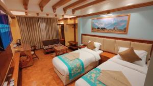 加德满都Sherpa Home Hotel的酒店客房设有两张床和电视。