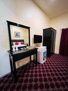 沙迦DANA HOTEL的酒店客房配有书桌和镜子