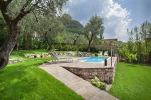 马尔切西内Villa Fani-Wellness & Relax的庭院内的游泳池,旁边设有长凳