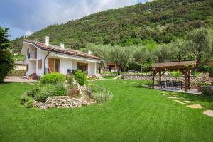 马尔切西内Villa Fani-Wellness & Relax的一座带绿色草坪的庭院