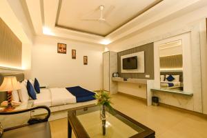 新德里Hotel Krishna Deluxe-By RCG Hotels的酒店客房设有一张床铺和一张玻璃桌