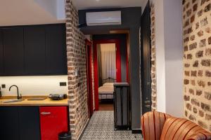 伊斯坦布尔Alness Residence的一间带红色橱柜的厨房和一间带卧室的房间
