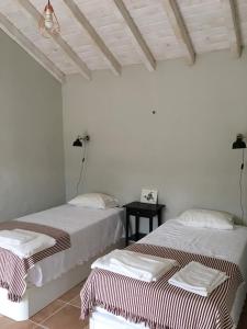 圣路易斯Monte Teu的白色墙壁客房的两张床