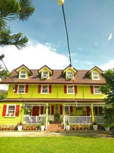 Santa RosaMadie's Place Bed & Breakfast in Santa Rosa, Laguna near Enchanted Kingdom的一座黄色的房子,有红色和白色的房子