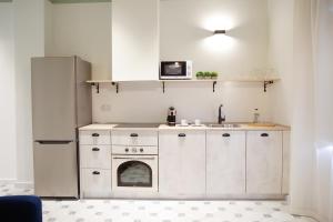 阿利坎特Casa Alberola Apartments的厨房配有白色橱柜和冰箱。