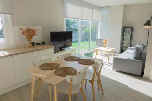 维戈Apartamentos Dunas de Samil的厨房以及带桌椅的起居室。
