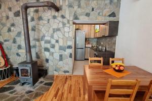 斯科普里ILIS House Matka的厨房配有燃木炉灶和木桌。