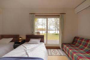 北塩原村Lakeside Hotels Kuore的一间卧室设有两张床和窗户。