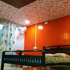 萨塔拉KAASH PATHAR DREAM HOUSE的一间卧室设有一张床和橙色的墙壁