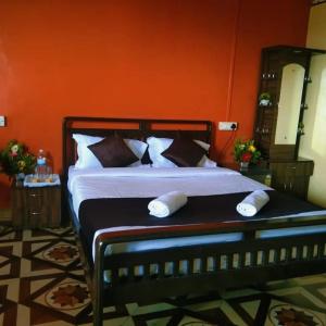 萨塔拉KAASH PATHAR DREAM HOUSE的一间卧室配有一张带橙色墙壁的大床
