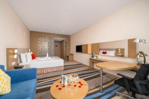 广州蔚徕酒店广州白云机场店(原白云机场智选假日酒店）的酒店客房带一张床、一张桌子和椅子