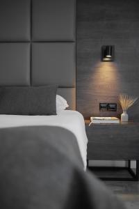 利马索尔Odysseia Hotel Kapetanios的一间卧室配有一张床和一个带台灯的边桌
