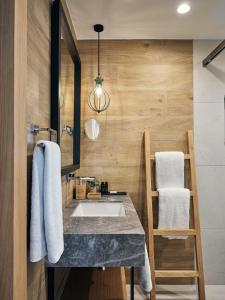 伊罗达伊罗达多姆斯傲途格精选酒店的一间带水槽和木墙的浴室