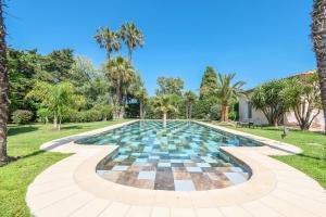 圣特罗佩Villa Alizée B&B的棕榈树公园内的游泳池