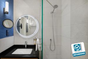 布达佩斯贺莉亚丹乌比斯酒店的浴室配有盥洗盆和带镜子的淋浴